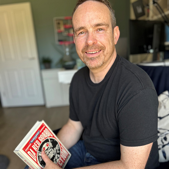 Andy, holding his book recommendation, Da Red Gobbo Collection