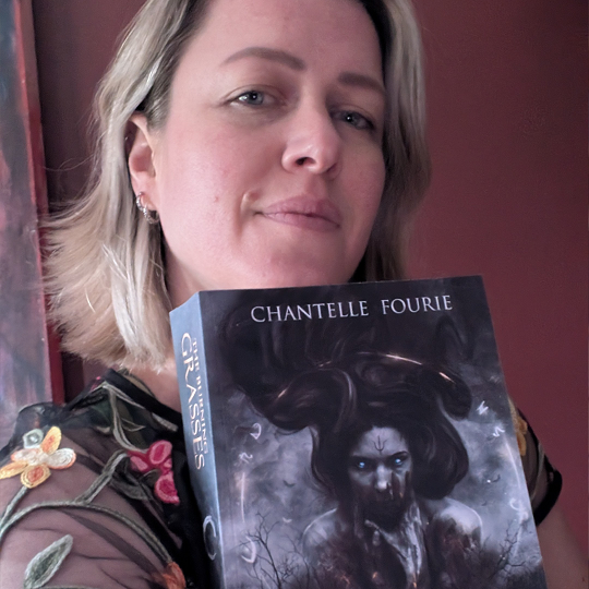 Chantelle, holding her book recommendation, The Burning Grasses