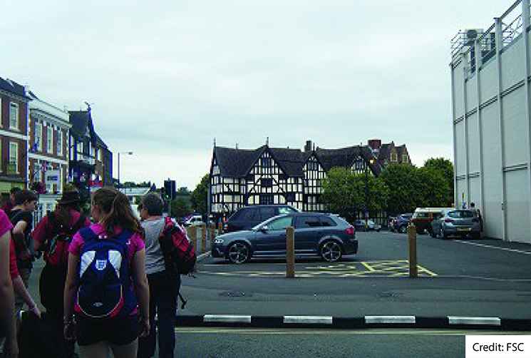 A small group of student walking across the road in Shrewsbury town