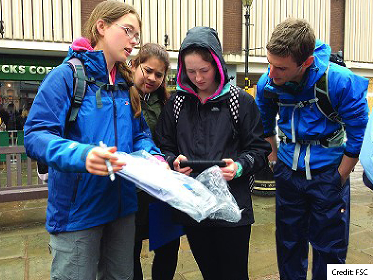 A group of students on a high street studying some data together