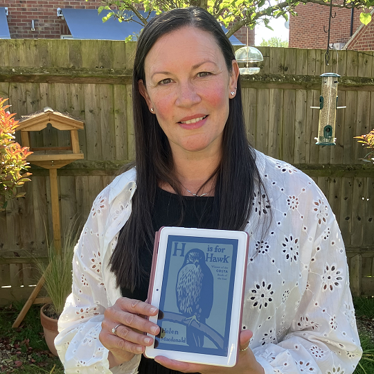 Lisa, holding her book recommendation, H is for Hawk